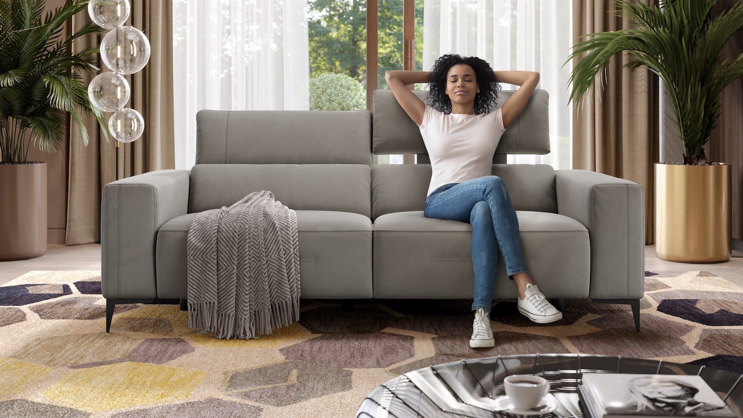 Frau entspannt auf modernem, grauem Ledersofa im Wohnzimmer.